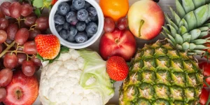 Aerial view of fruit and vegetables that are high in fibre on a white table that can help restore your gut health.